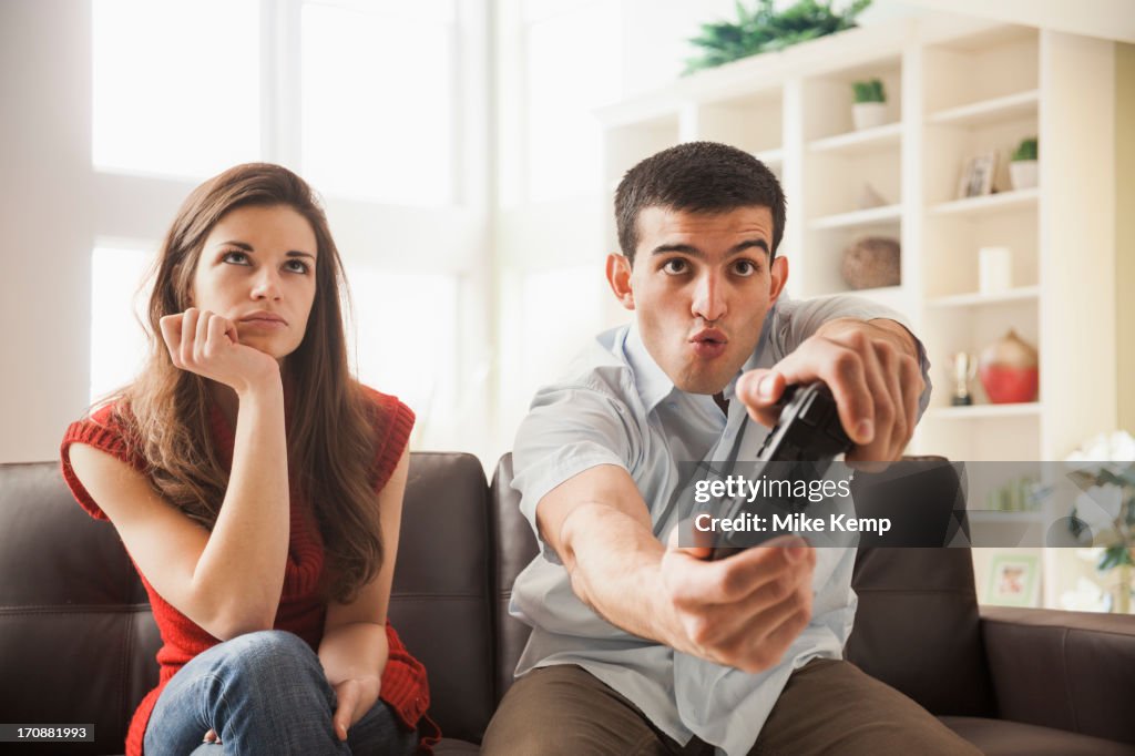 Woman watching boyfriend play video games