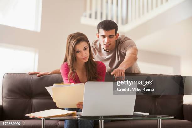 couple reading papers at laptop together - paid search stock pictures, royalty-free photos & images