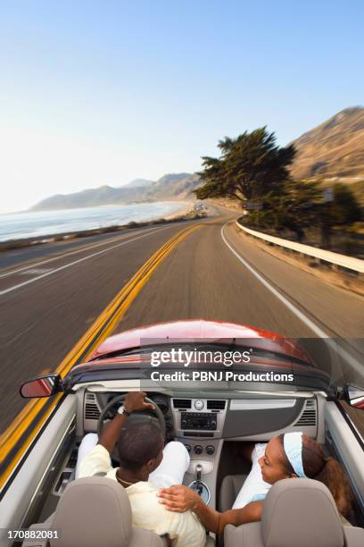 couple driving convertible on coastal road - malibu beach california stock pictures, royalty-free photos & images