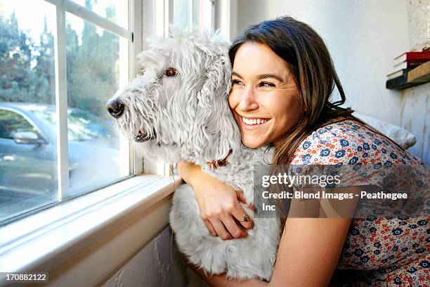 caucasian woman hugging dog at window - dog in car window stock pictures, royalty-free photos & images