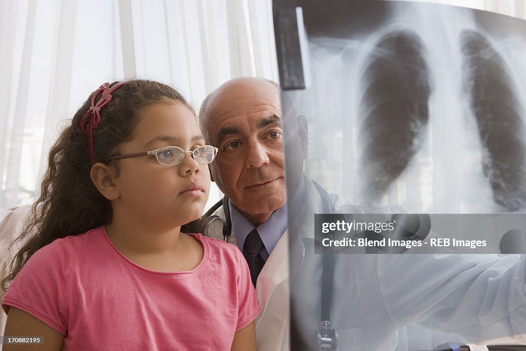 Hispanic doctor showing chest x-rays to patient