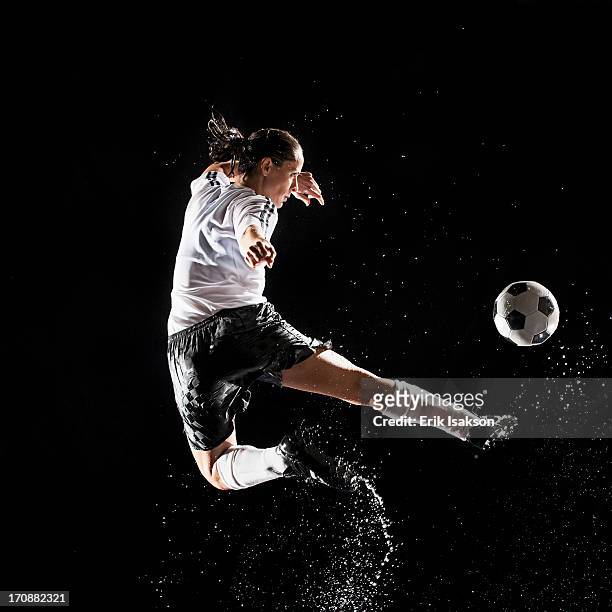 hispanic soccer player splashing in water - woman football stock-fotos und bilder