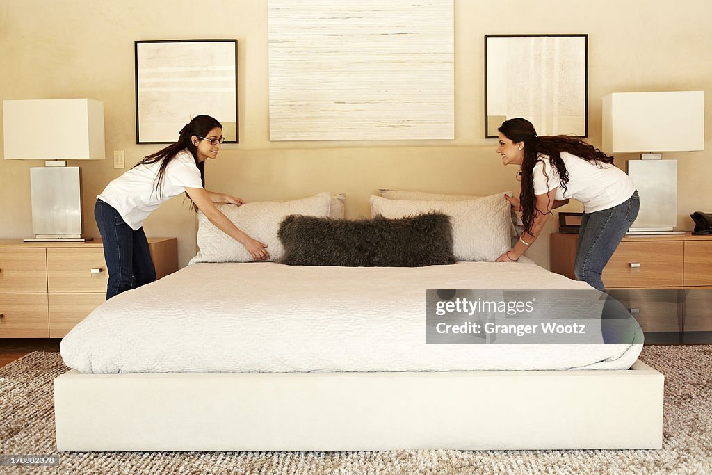 Hispanic women making bed