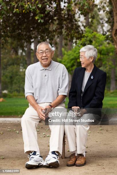 older asian couple smiling together outdoors - japanese senior couple stockfoto's en -beelden