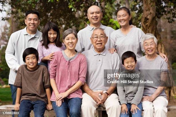 asian family smiling together outdoors - korean ethnicity stock-fotos und bilder