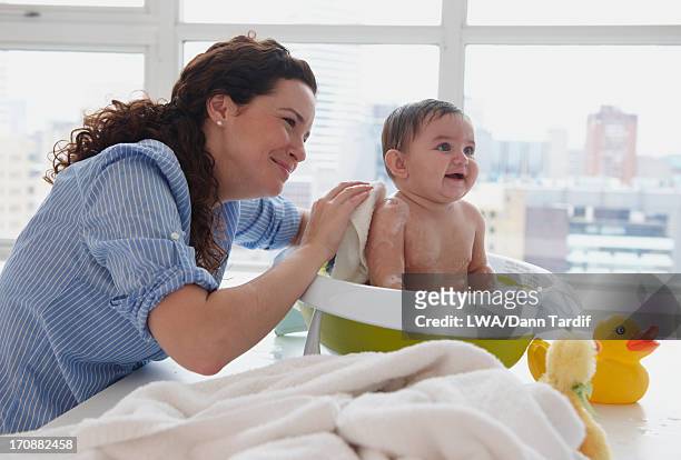 mother bathing baby on counter top - baby bath toys stock pictures, royalty-free photos & images