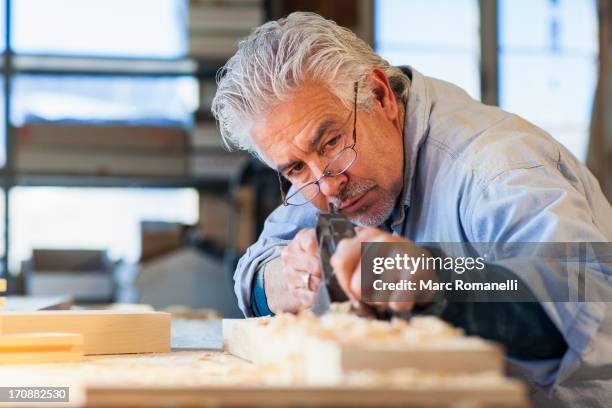 hispanic craftsman working in studio - wood shaving stock pictures, royalty-free photos & images