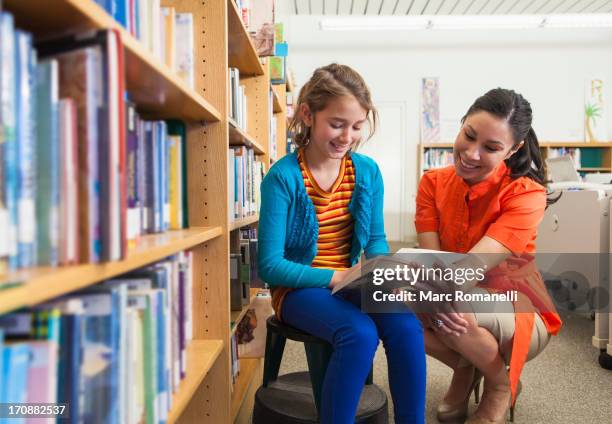 teacher and student reading together in library - librarian stock pictures, royalty-free photos & images