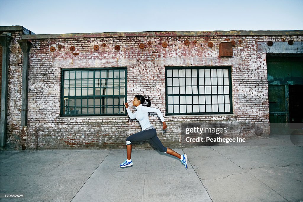 Black woman running on city street