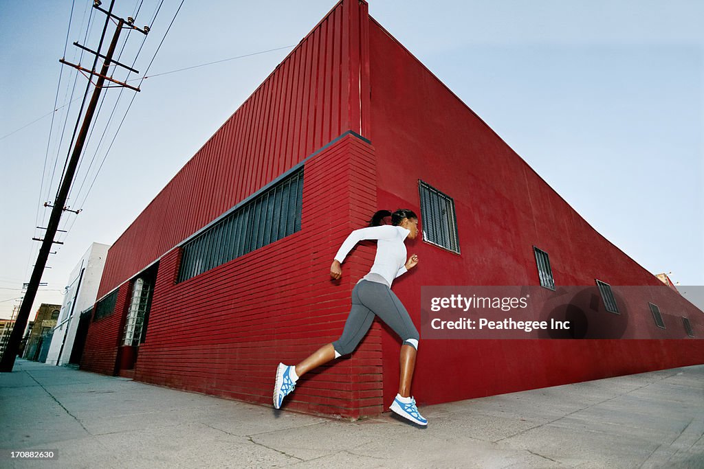 Black woman running on city street