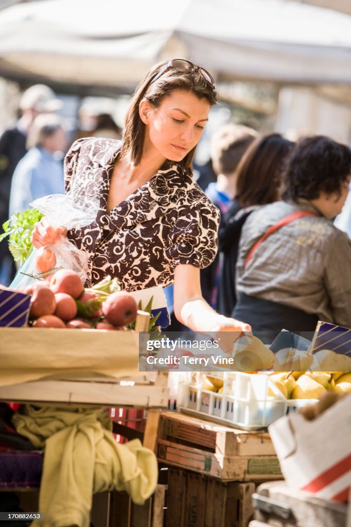Caucasian woman buying produce at market