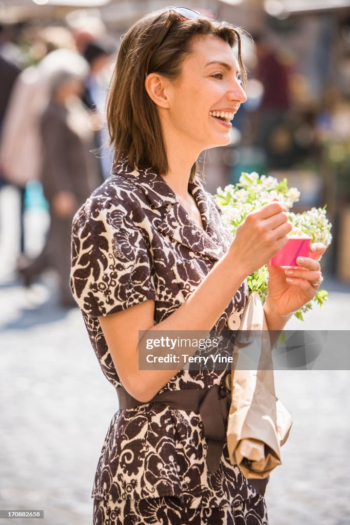 Caucasian woman eating ice cream on city street