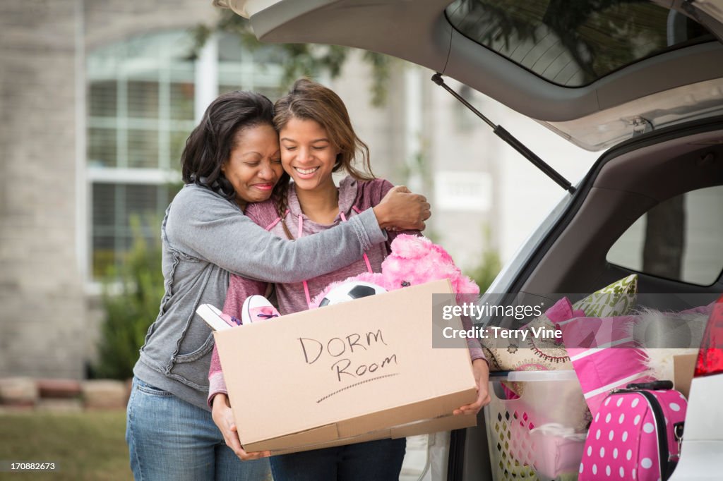 African American mother helping daughter pack for college