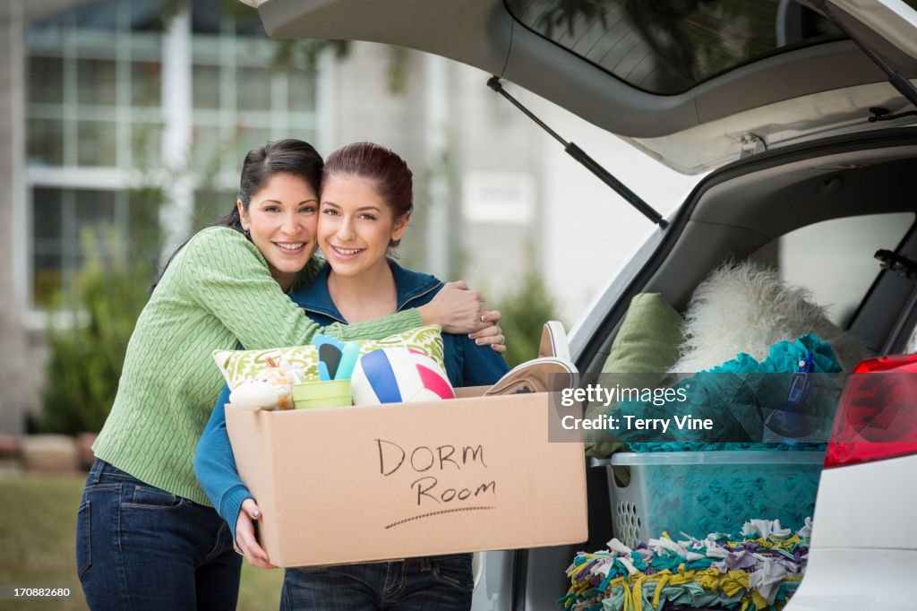 Hispanic mother helping daughter pack for college