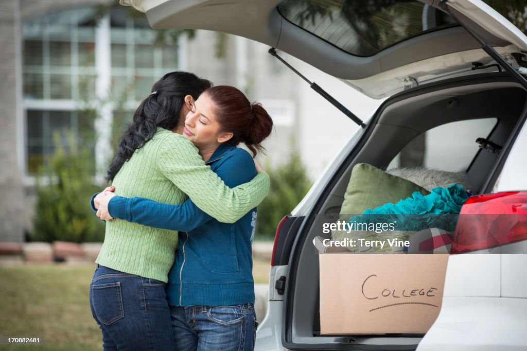 Hispanic mother helping daughter pack for college