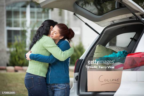 hispanic mother helping daughter pack for college - leaving stock-fotos und bilder