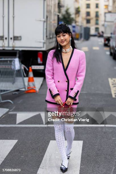 Guest wears pink jacket, mini skirt, red Dior bag, white knee high tights outside Alessandra Rich during the Womenswear Spring/Summer 2024 as part of...