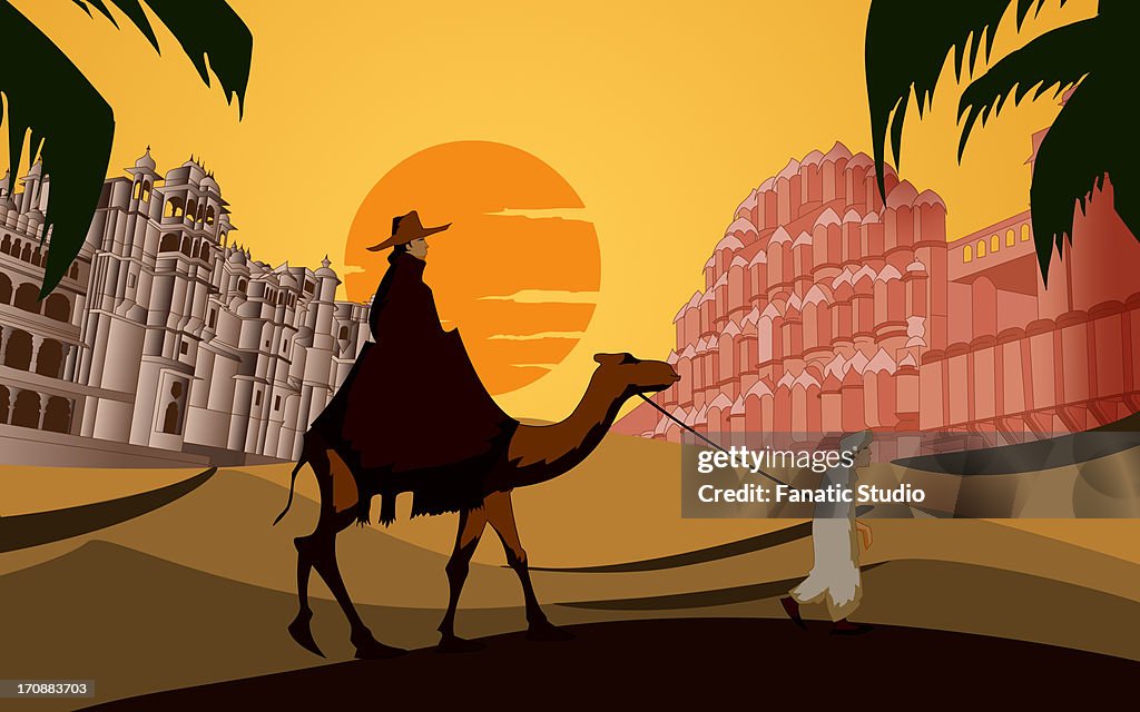 Tourist riding a camel in front a palace, Hawa Mahal, Jaipur, Rajasthan, India
