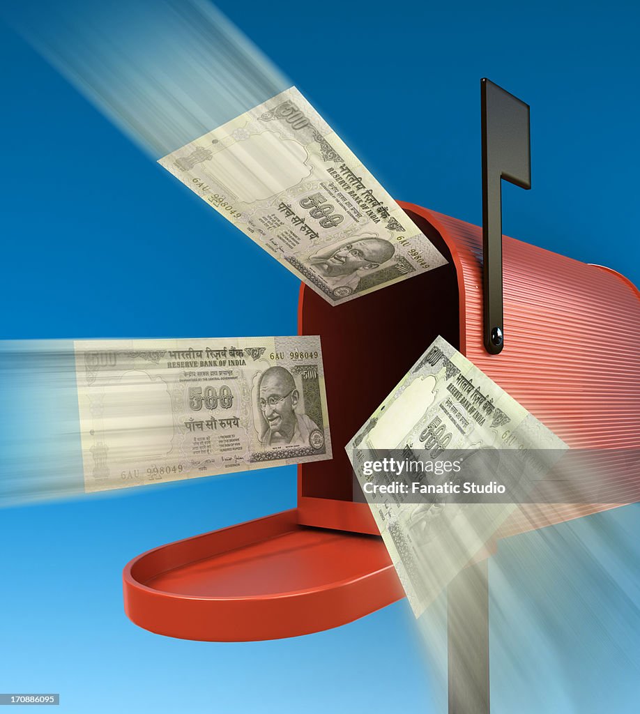 Indian Rupee note flying out from mailbox