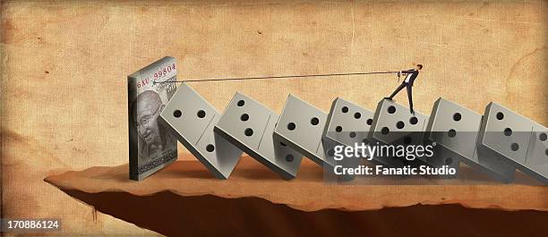 businessman standing on dominoes struggling for money - indian currency stock illustrations