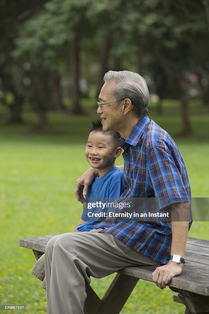 Grandpa chatting with his grandson in park