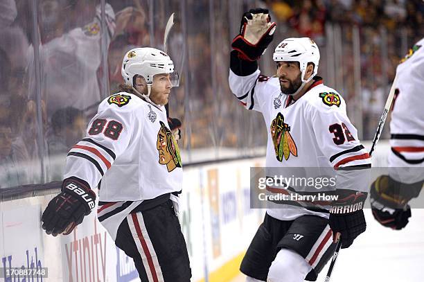 Patrick Kane of the Chicago Blackhawks celebrates with Michal Rozsival after Kane scores a goal in the second period against the Boston Bruins in...