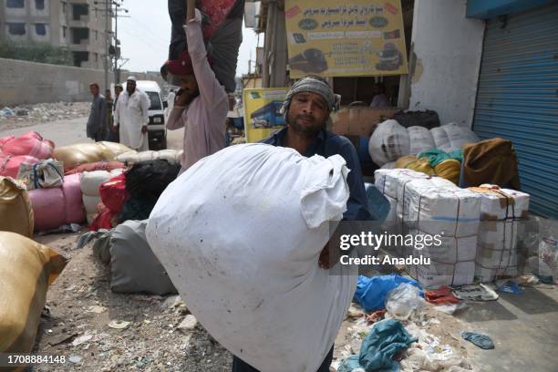 Afghan refugees carry their packs to leave the Pakistani port city of Karachi to return to Afghanistan following the Pakistani government's decision...