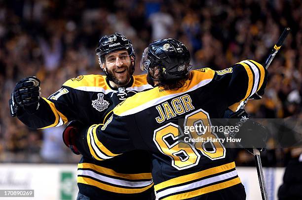 Patrice Bergeron of the Boston Bruins celebrates with Jaromir Jagr after a goal in the third period against the Chicago Blackhawks in Game Four of...