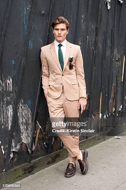 Model Oliver Cheshire wears Zegna shoes, Martin Margiela suit, Reiss Shirt and Respect sunglasses on day 2 of London Collections: Men on June 17,...