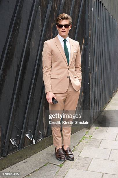 Model Oliver Cheshire wears Zegna shoes, Martin Margiela suit, Reiss Shirt and Respect sunglasses on day 2 of London Collections: Men on June 17,...