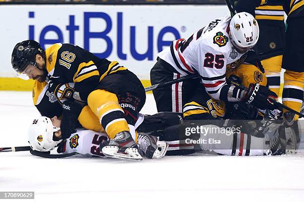 Kaspars Daugavins of the Boston Bruins pins down Andrew Shaw of the Chicago Blackhawks in Game Four of the 2013 NHL Stanley Cup Final at TD Garden on...