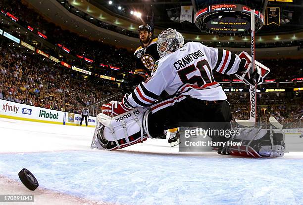 Johnny Boychuk of the Boston Bruins scores a goal against Corey Crawford of the Chicago Blackhawks during the third period in Game Four of the 2013...