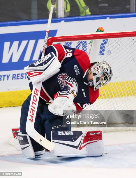 Andrew Oke of the Saginaw Spirit makes a save as the puck goes under his mask in the third period against the Kitchener Rangers at Kitchener Memorial...