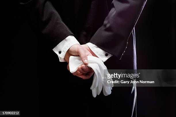 butler holdin white gloves behind back - regole dell'etichetta foto e immagini stock