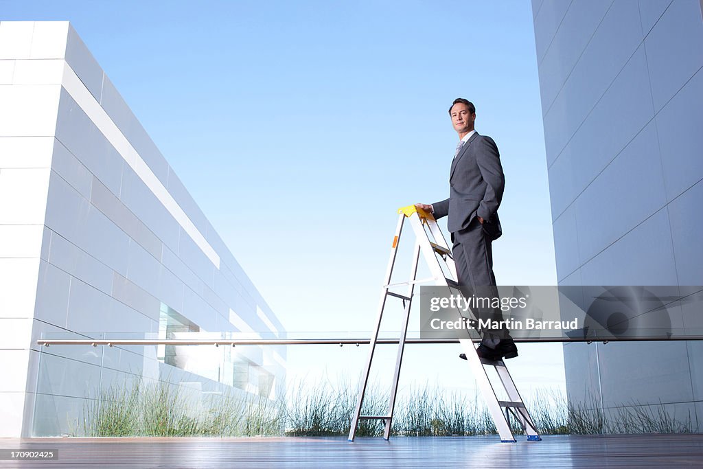 Hombre de negocios de pie en la escalera en el balcón