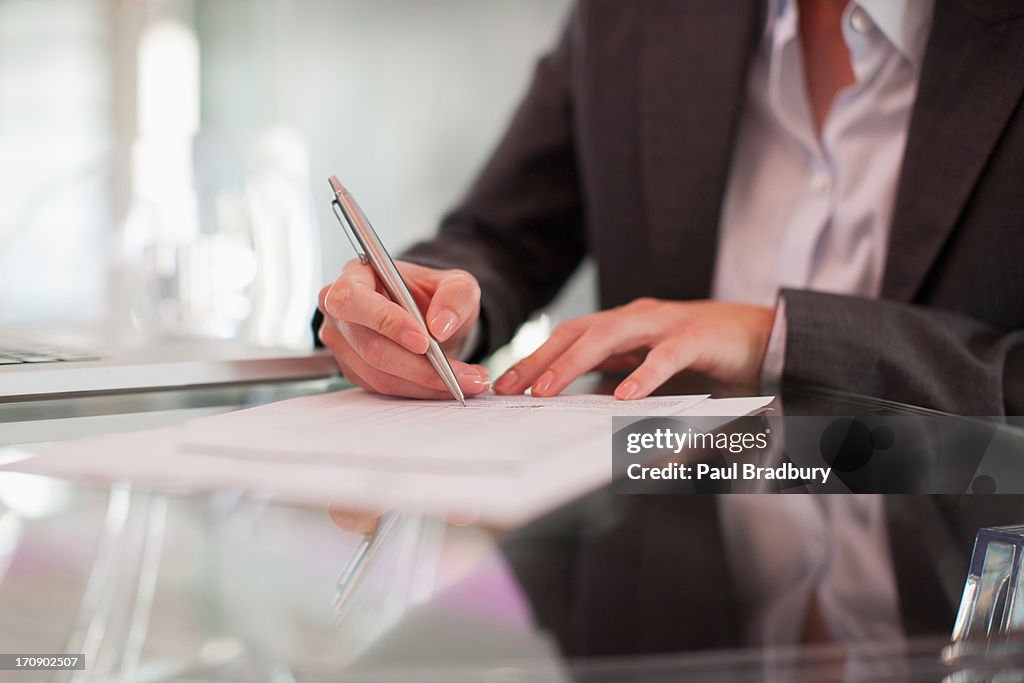 Donna d'affari scrivendo su Carta al banco