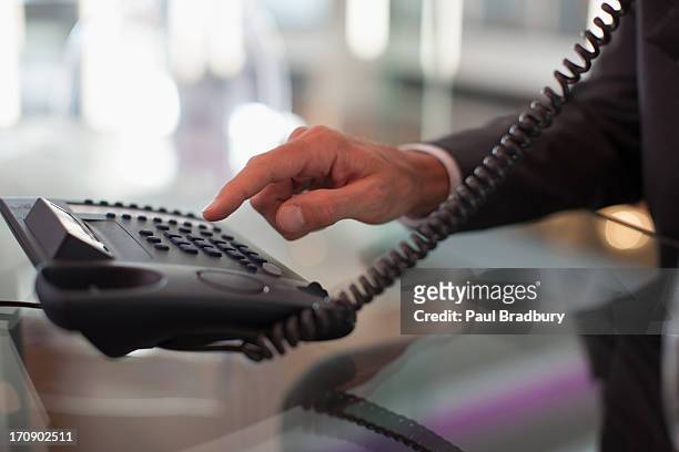 uomo d'affari telefono in ufficio di composizione - landline phone foto e immagini stock