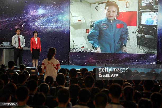 Girl in a school in Beijing asks Chinese female astrounaut Wang Yaping questions as Wang delivers a lesson to students from Tiangong-1 space module...