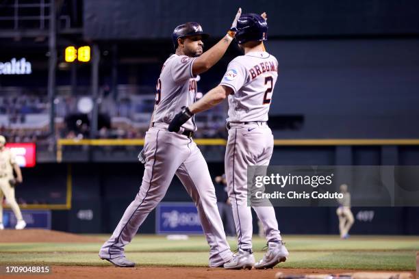 Jose Abreu of the Houston Astros high fives Alex Bregman after hitting an RBI ground rule double during the sixth inning against the Arizona...