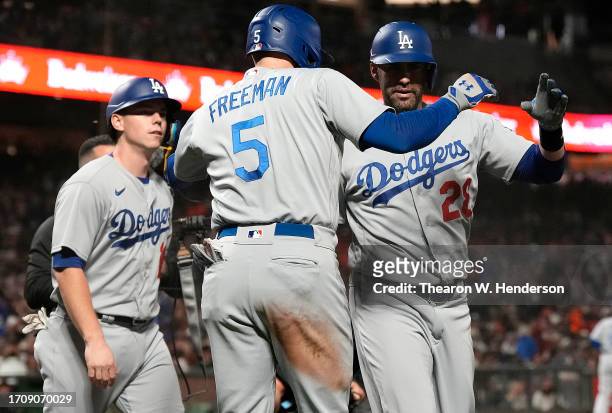Martinez of the Los Angeles Dodgers is congratulated by Freddie Freeman and Will Smith after Martinez hit a three-run home run against the San...