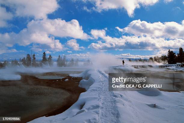 Footsteps in the snow between the thermal water pools of the West Thumb Geyser Basin, Yellowstone Lake, Yellowstone National Park , Wyoming, United...
