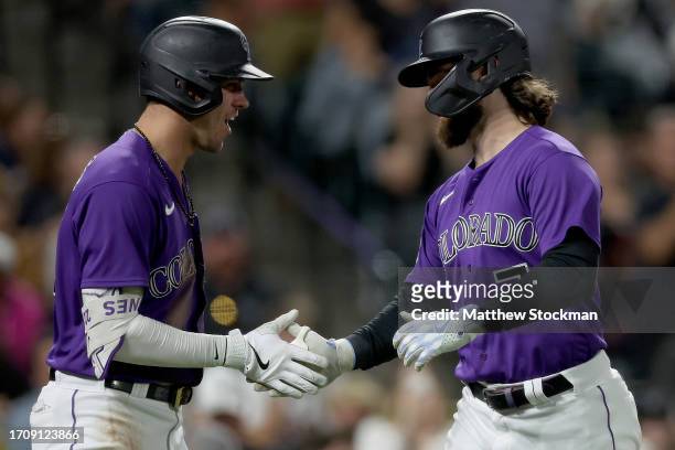 Brendan Rogers of the Colorado Rockies celebrates with Nolan Jones after hitting a solo home run against the Minnesota Twins in the fifth inning at...