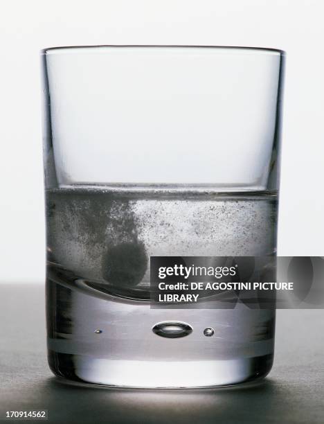 Glass with a medicinal tablet dissolving in the water.