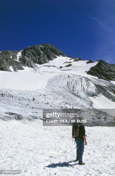 Hiker at the Glacier de Peclet, Val Thorens, Vanoise National Park , Savoie, France.