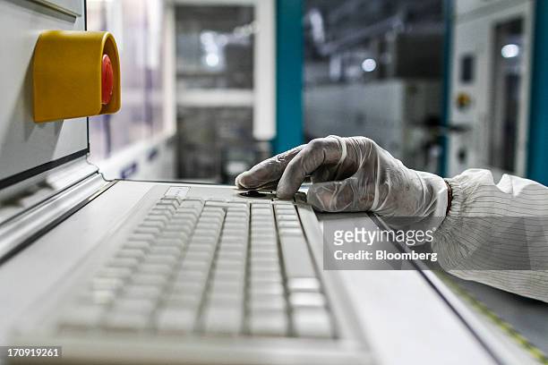 An employee works on an NPC Inc. Cell Tester machine on the solar cell production line at the Tata Power Solar Systems Ltd. Manufacturing plant in...