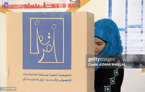 An Iraqi woman casts her vote at a polling station during provincial elections on June 20, 2013 in the Anbar province. Iraqis in two Sunni-majority...