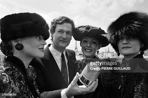 French fashion designer Jean-Louis Scherrer , surrounded by models, holds up his "Gold Thimble" in Paris on July 31, 1980 which he was awarded for...
