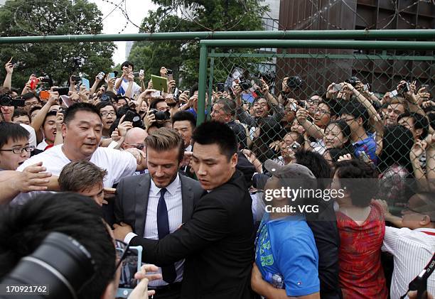 David Beckham is surrounded by fans as he visits Tongji University on June 20, 2013 in Shanghai, China.