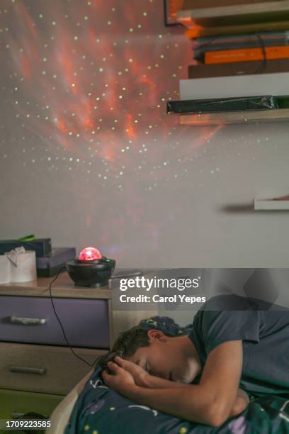 male on bed surrounded by sheets and duvets and pillows.headache - yawning is contagious stock pictures, royalty-free photos & images