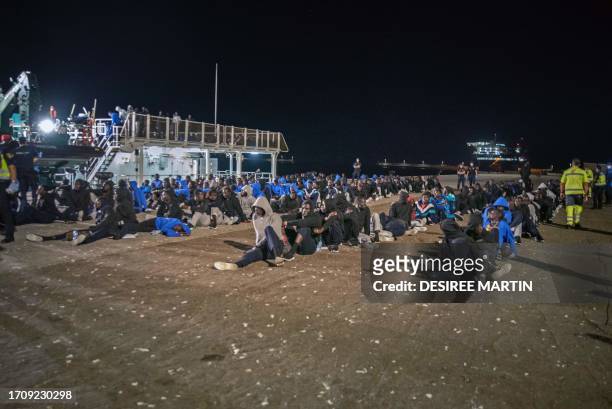 Migrants wait on the pier after disembarking from the Spanish Civil Guard vessel Rio Segura in the port of Granadilla, island of Tenerife, Spain, on...